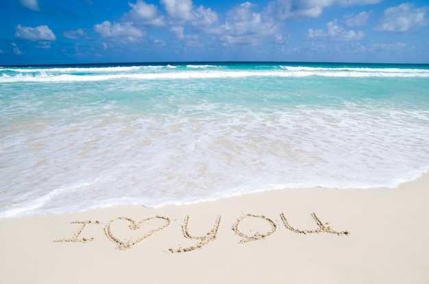 Je t'aime. Citation écrite au bord de la mer dans une plage tropicale