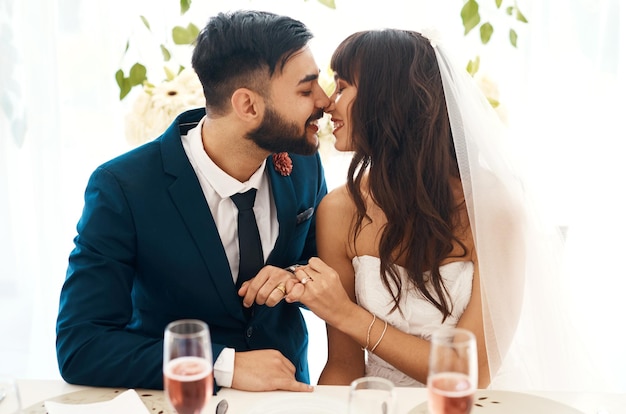 Je t'aimerai pour toujours Photo recadrée d'un couple de jeunes mariés assis ensemble à leur réception de mariage