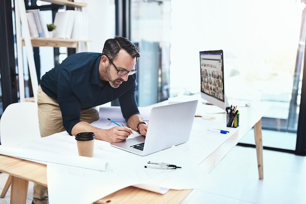 Je trouverai ce que je cherche en ligne Photo d'un architecte mâle mature travaillant sur son ordinateur portable