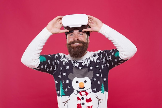 Je vois que les autres ne voient pas. l'homme porte des lunettes de réalité virtuelle. imaginez la meilleure fête de Noël. heureux hipster barbu dans des lunettes vr. chandail d'hiver homme jouer au jeu. activité intérieure vs activité extérieure. Réalité virtuelle.