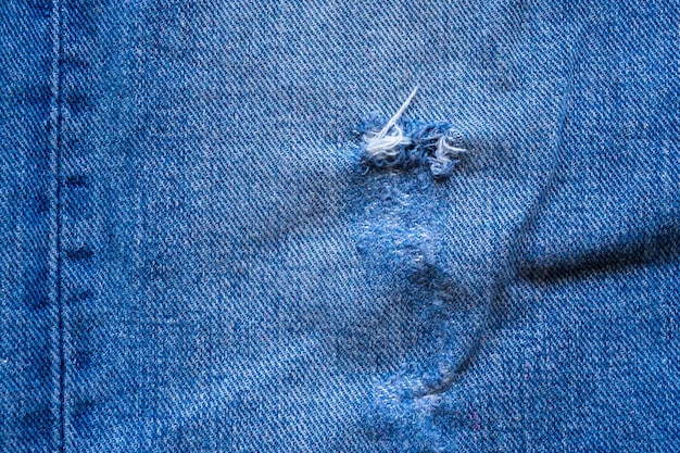 Jean bleu denim déchiré la texture de la conception de la mode bouchent la vue de dessus de fond