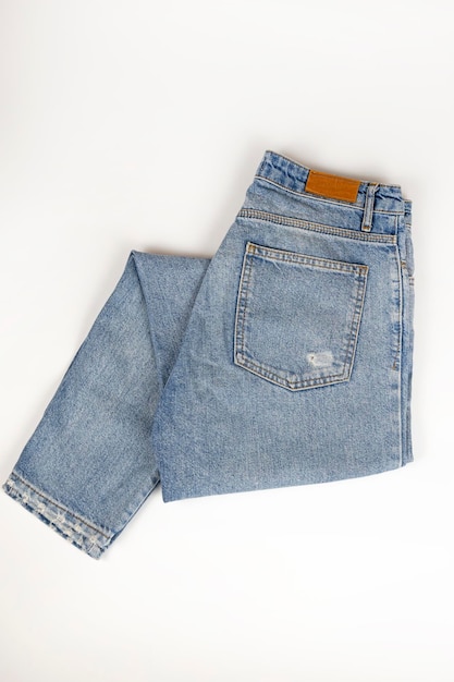 Photo jeans bleu plié sur une vue de dessus de fond blanc gros plan