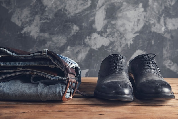 Jeans avec ceinture et chaussures sur mur en bois