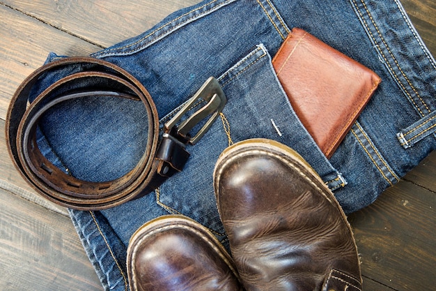 Jeans ceinture chaussures et portefeuille sur fond de bois