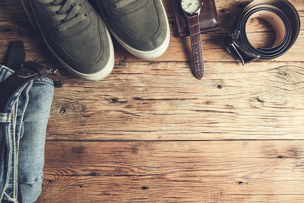 Photo jeans avec chaussures et montre avec ceinture sur table