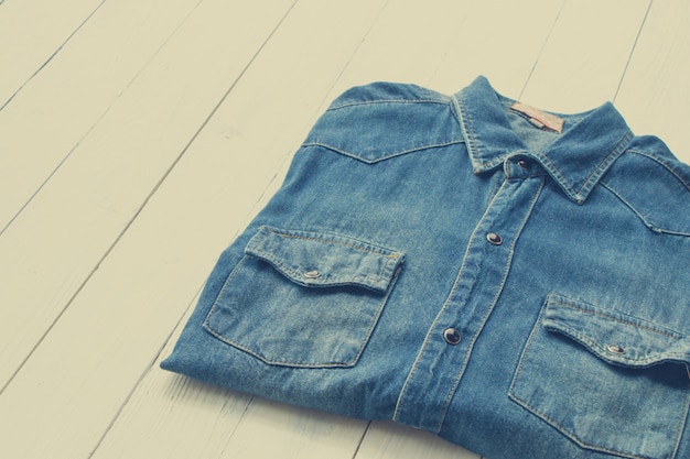 Jeans chemise en jean mis sur fond de table en bois