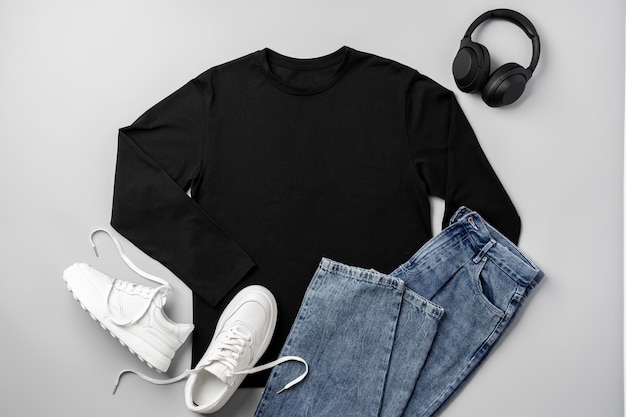 Jeans T-shirt et baskets blanches sur fond gris vue supérieure