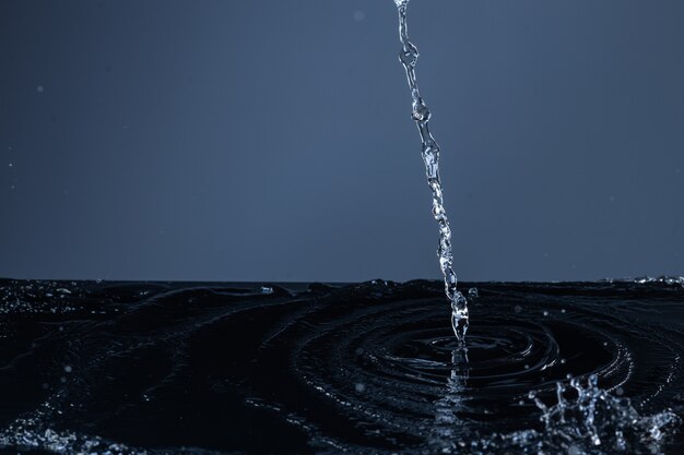 Jet d'eau propre tombant sur une surface noire