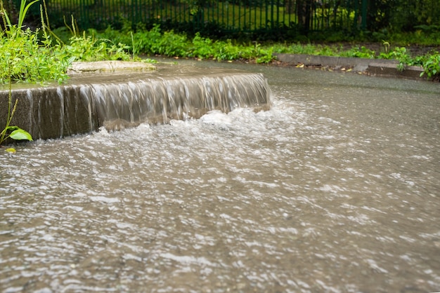 Le Jet D'eau S'écoule Vers La Zone Piétonne. Temps D'automne Pluvieux. De Fortes Pluies. Scènes De Rue Sous La Pluie.