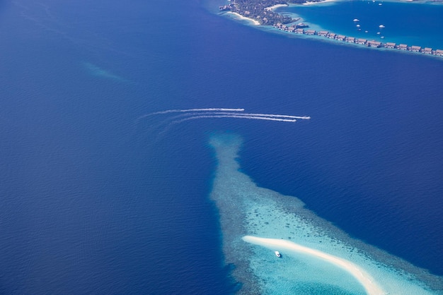 Jet ski ayant dans le lagon océanique des Maldives. Vue aérienne de style de vie de luxe sur le complexe de luxe des Maldives