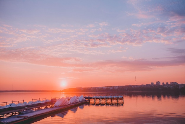 jetée en bois avec des bateaux au coucher du soleil