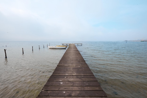 Jetée en bois sur le lac dans une ambiance brumeuse