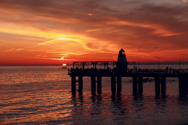 Jetée du phare et coucher de soleil sur l'eau