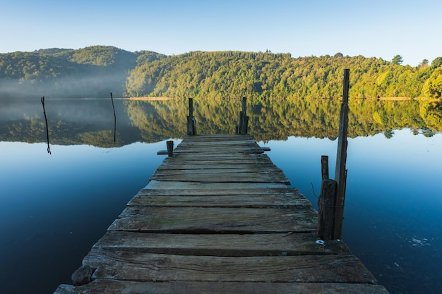 Photo une jetée sur un lac calme.