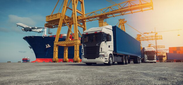 Une jetée pendant la journée Le ciel est bleu vif Il y a un grand navire de fret amarré le long de la jetée Il y avait un grand camion garé Le camion était plein de marchandises