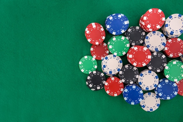 Jetons de casino colorés sur table en feutre vert se bouchent. Notion de jeu. Jouer au poker et à d'autres jeux de hasard