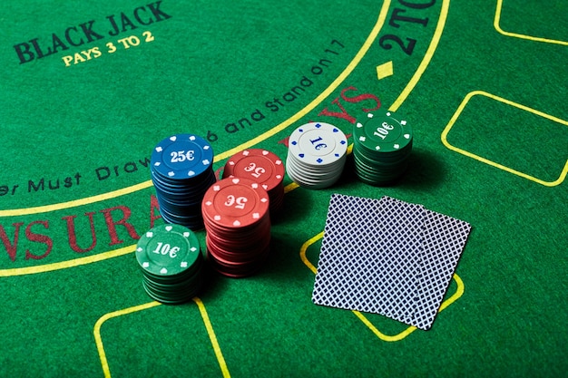 Jetons de casino et jeu de cartes allongé sur une table de casino verte, concept de jeu de poker.