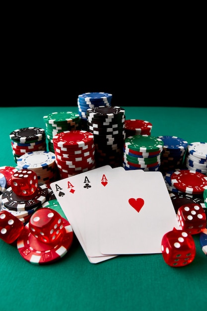 Jetons de casino à jouer aux cartes et aux dés sur une table en tissu vert