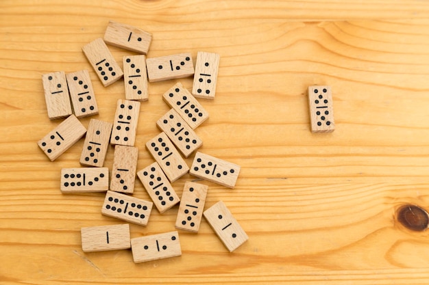 Jetons de dominos en bois éparpillés sur une surface également en bois