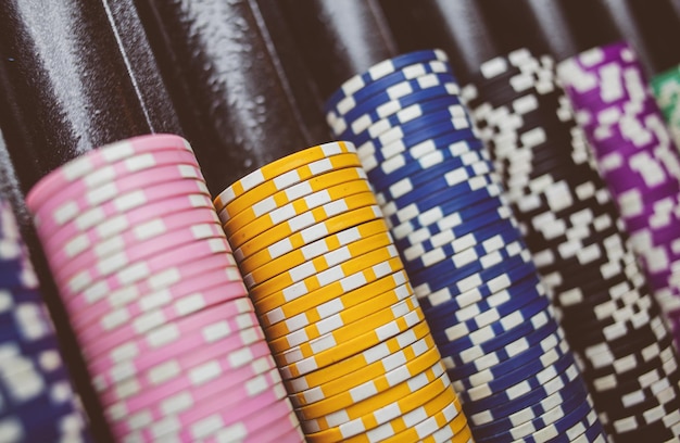 Les jetons de poker colorés du casino se trouvent sur la table de jeu dans le traitement de photo vintage de la pile