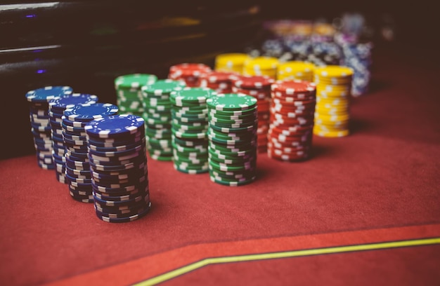 Les jetons de poker colorés du casino se trouvent sur la table de jeu dans le traitement de photo vintage de la pile