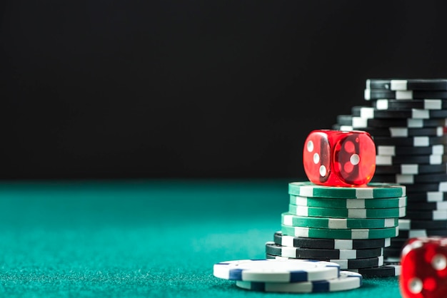 Jetons de poker et dés sur fond de casino de table de poker vert