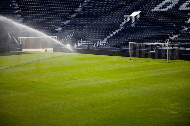 Photo jets d'eau arrosant un stade de football.