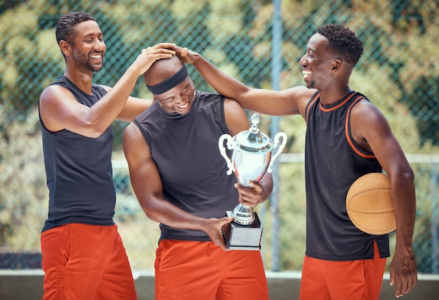 Jeu de basket-ball sports d'équipe et vainqueur du trophée dans une compétition sportive sur la collaboration sur le terrain pour la victoire et le travail d'équipe pour le succès lors d'un événement Un athlète africain célèbre le prix et la réussite du champion