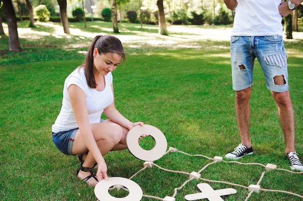 Jeu Big Tic Tac Toe. Guy et fille jouant à l'extérieur.