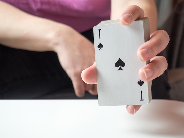 Photo un jeu de cartes à jouer dans la main d'une fille avec un as de pique