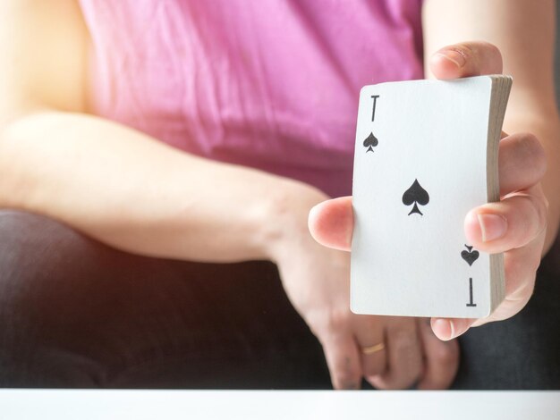 Un jeu de cartes à jouer dans la main d'une fille avec un as de pique