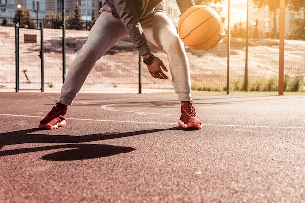 Jeu dynamique. Beau jeune homme tenant un ballon de basket tout en jouant à un jeu