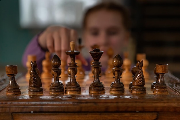 Un jeu d'échecs La fille tient un pion dans ses mains Style photo dramatique sombre dans des couleurs sombres