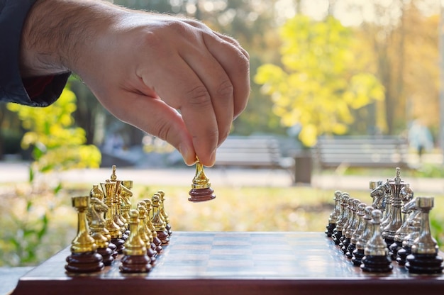 Jeu d'échecs en plein air. Échiquier avec des chiffres sur un fond de parc en automne, gros plan. Le pion fait le premier pas. Mise au point sélective. Stratégie réussie.