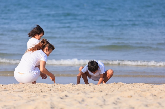 Jeu de famille asiatique sur la plage tropicale