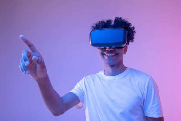 Jeu. Jeune homme afro-américain à lunettes vr appréciant le jeu