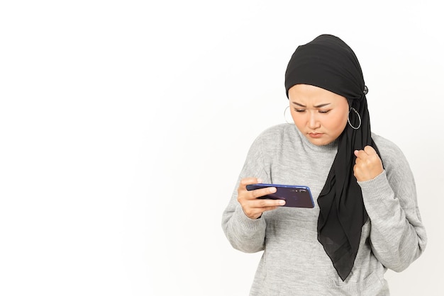 Jeu mobile sur Smartphone de belle femme asiatique portant le hijab isolé sur fond blanc