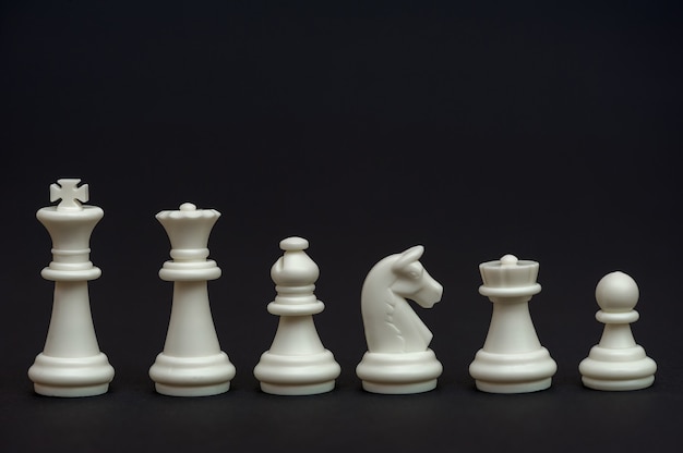Jeu de pièces d'échecs blanches sur fond noir Jeu de table d'échecs