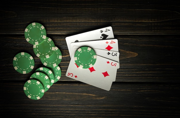 Photo jeu de poker avec deux combinaisons de paires de jetons et de cartes sur la table noire vintage dans le club de poker