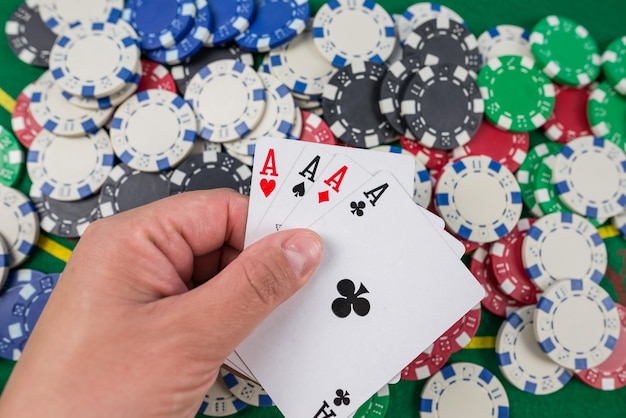 Jeu de poker, le joueur tient des cartes dans sa main sur une table de poker verte Concept de jeu de poker