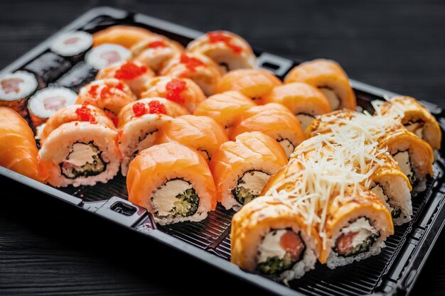 Photo un jeu de sushis avec du saumon sur un fond noir