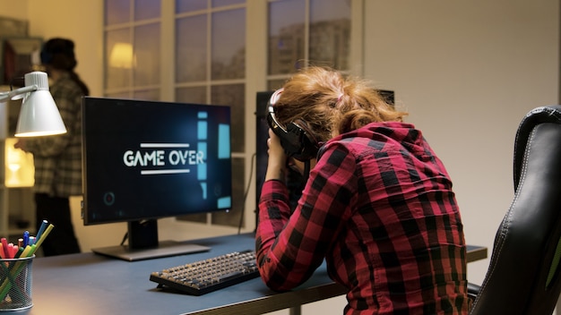 Jeu terminé pour une joueuse caucasienne professionnelle assise sur une chaise de jeu. Homme portant un casque vr.