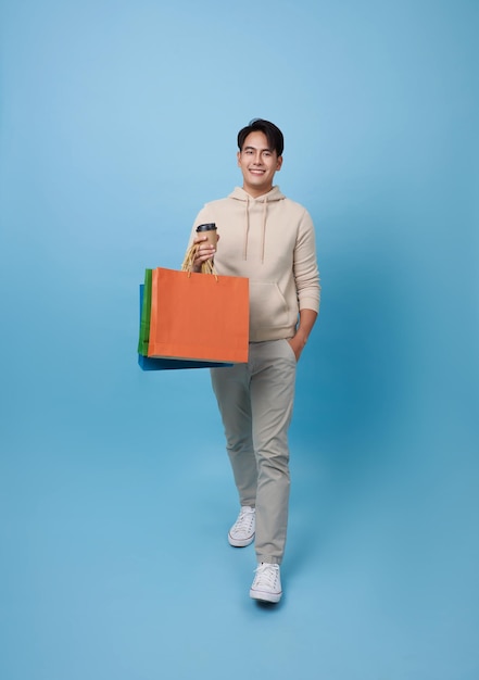 Photo un jeune acheteur asiatique attrayant marche et tient un sac à provisions.