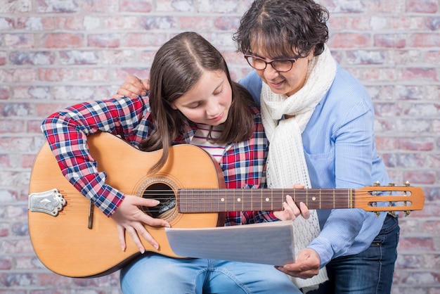 Jeune adolescent apprenant à jouer de la guitare avec son professeur