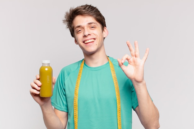 Photo jeune adolescent homme expression heureuse et tenant un smoothie