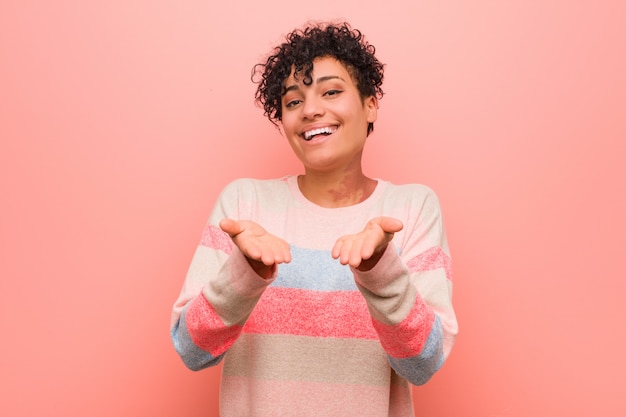 Jeune adolescent mixte afro-américaine femme tenant quelque chose avec des palmiers