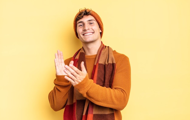 Jeune adolescent se sentant heureux et réussi, souriant et frappant des mains, se félicitant d'un applaudissement