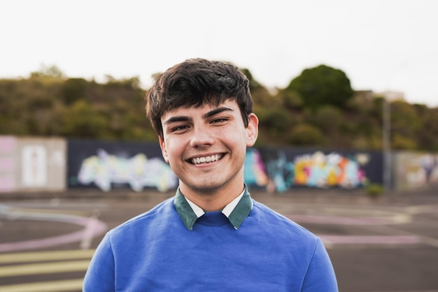 Jeune adolescent souriant à la caméra en plein air