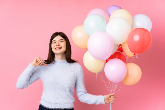 Jeune adolescent tenant beaucoup de ballons fier et satisfait de lui-même