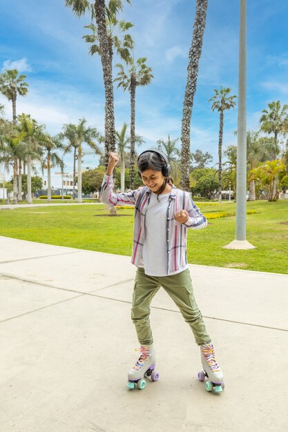 Une jeune adolescente aime la musique en faisant du patin à roues alignées